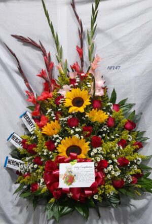 Arreglo floral rosas, girasol, gladiolos y chocolatinas