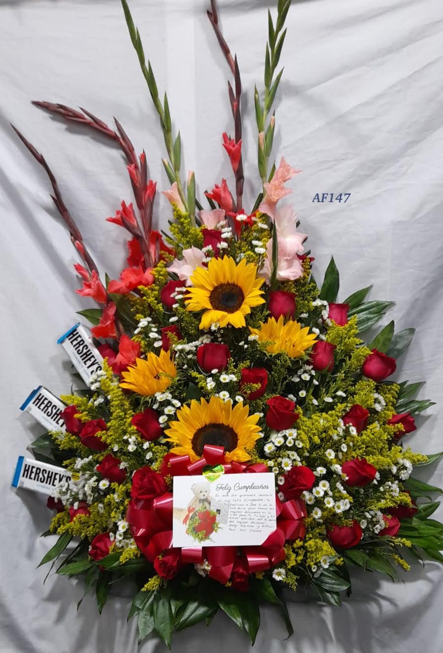 Arreglo floral rosas, girasol, gladiolos y chocolatinas