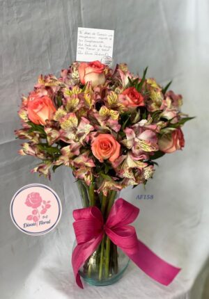 Arreglo rosas y astromelias en jarrón de vidrio